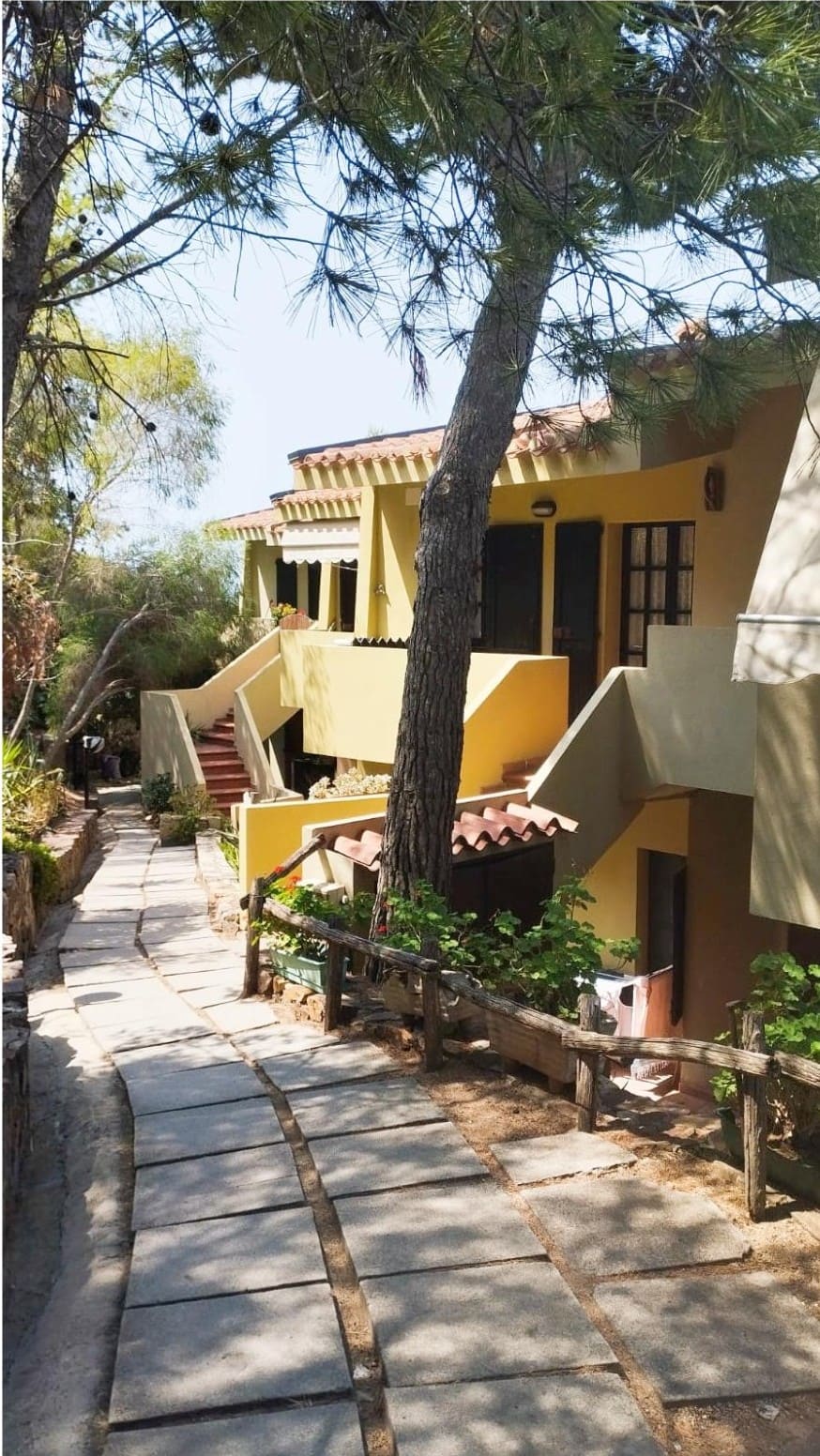 La villa gialla tra gli alberi vista dal sentiero