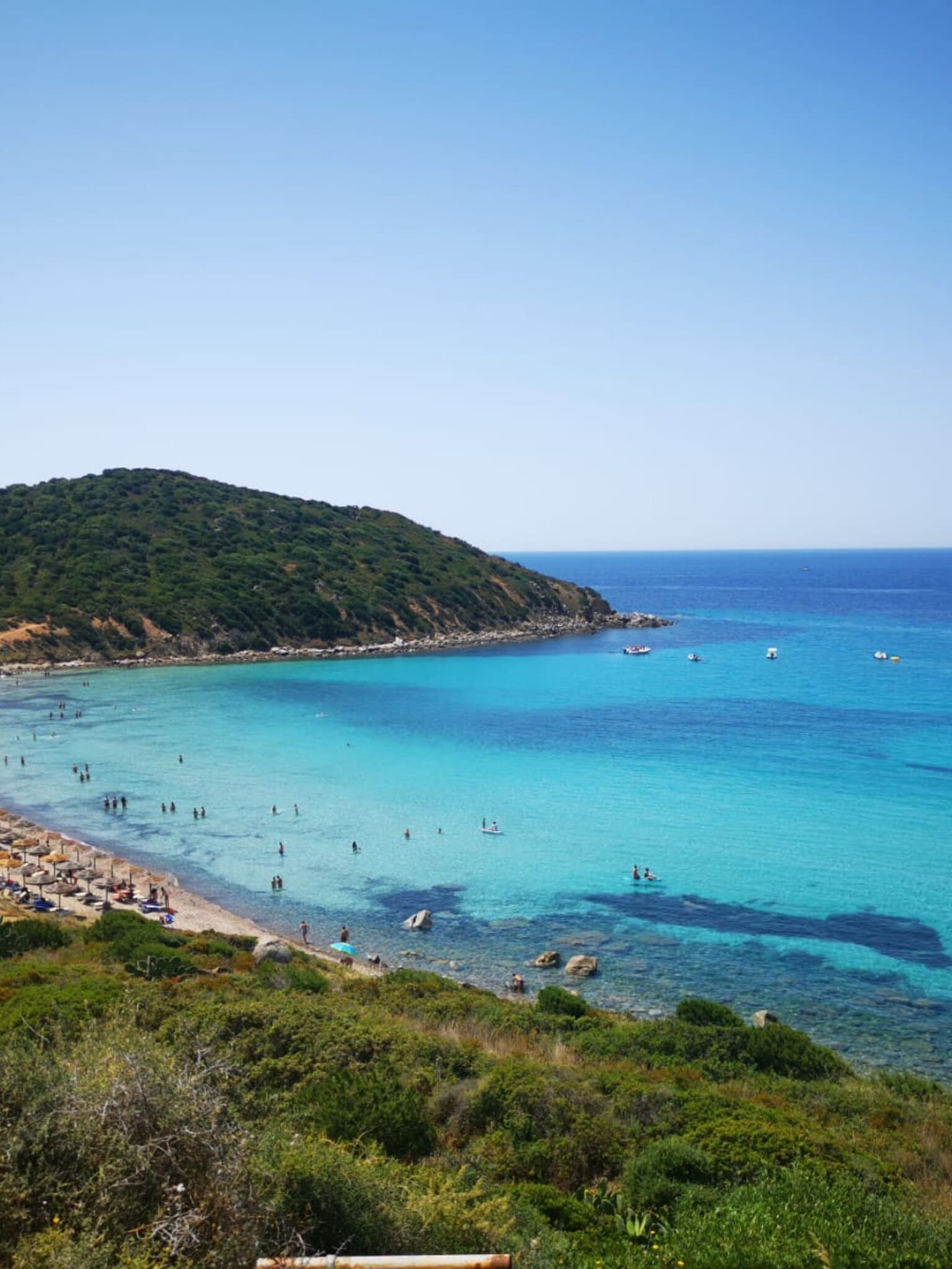 Spiaggia di Mari Pintau con mare turchese e promontorio verde