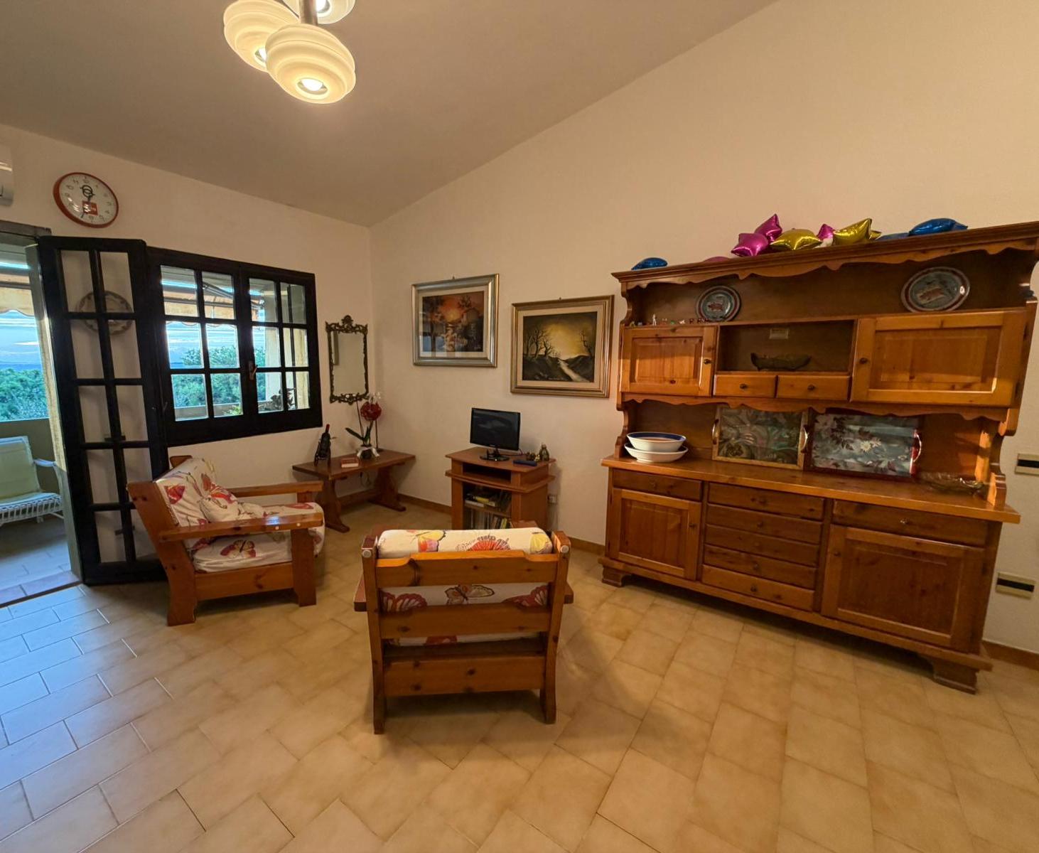 Sala con credenza in legno e poltrone