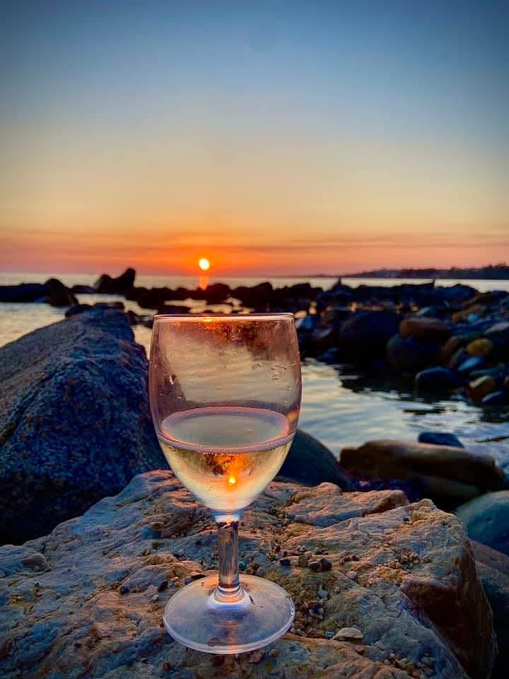 Calice di vino al tramonto sul mare