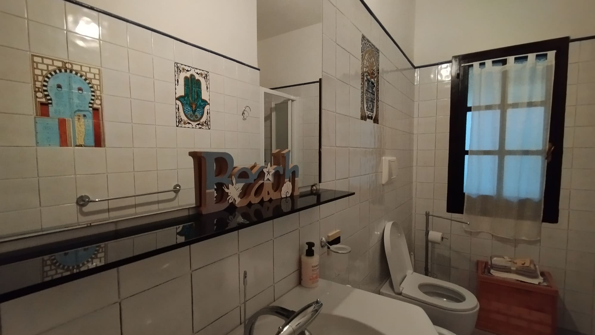 Bagno con ripiano scuro e doccia